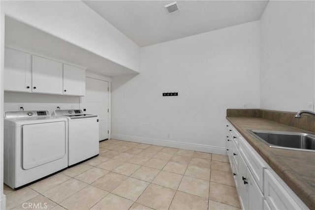 laundry area featuring visible vents, washer and clothes dryer, a sink, cabinet space, and baseboards