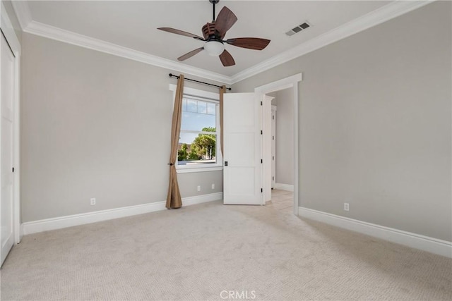 unfurnished bedroom featuring light colored carpet, crown molding, and baseboards