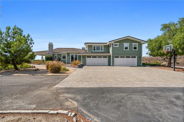 view of front of property featuring decorative driveway and a garage