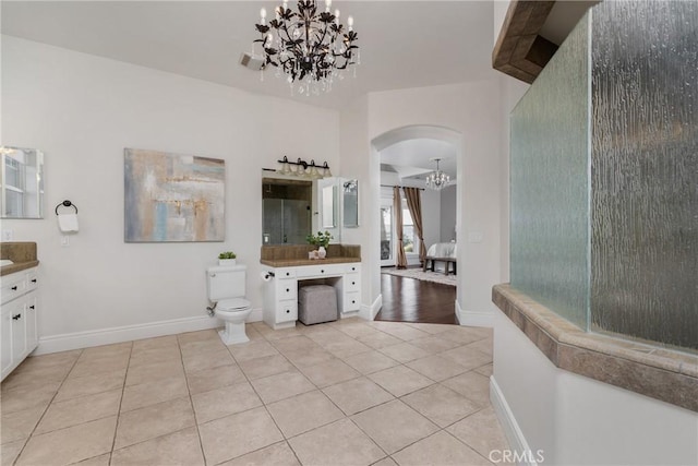 full bathroom with vanity, baseboards, tile patterned floors, toilet, and a chandelier