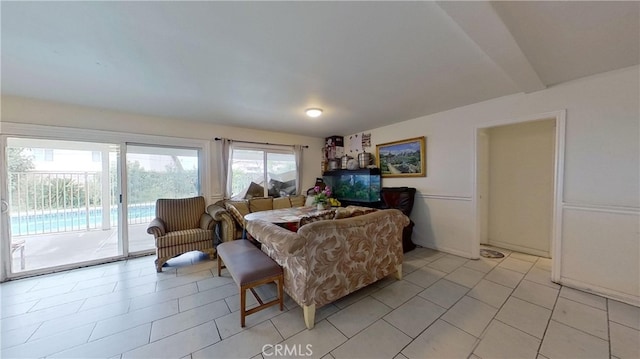 living room featuring beam ceiling and light tile patterned floors