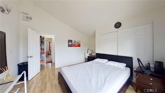 bedroom with light hardwood / wood-style flooring, a closet, and lofted ceiling