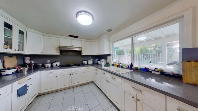 kitchen with gas cooktop, sink, and white cabinetry