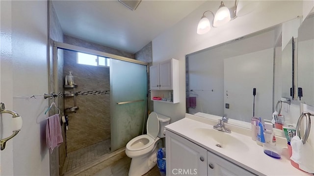 bathroom with tiled shower, vanity, and toilet