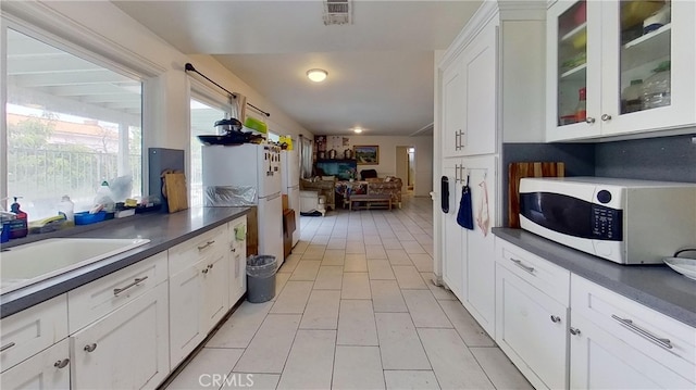 kitchen with white cabinets, sink, and white appliances