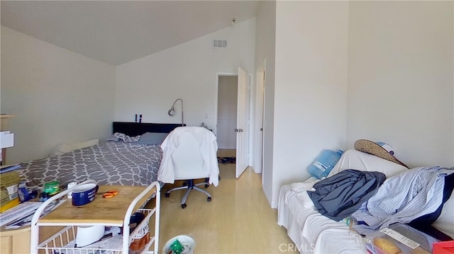 bedroom featuring light wood-type flooring and lofted ceiling