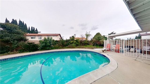 view of swimming pool featuring a diving board and a patio area