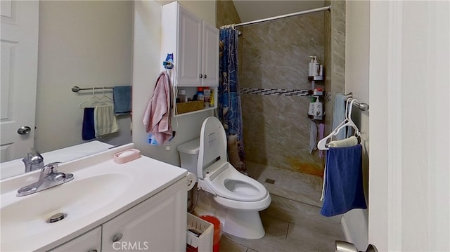 bathroom with vanity, tile patterned flooring, toilet, and curtained shower