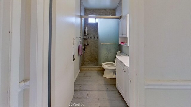 bathroom featuring vanity, tile patterned flooring, toilet, and an enclosed shower