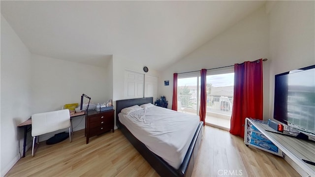 bedroom with light hardwood / wood-style flooring, access to exterior, and high vaulted ceiling