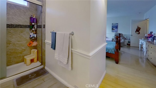 bathroom featuring walk in shower, hardwood / wood-style flooring, and vanity