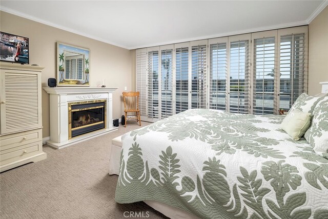 bedroom featuring light colored carpet, a fireplace, and ornamental molding