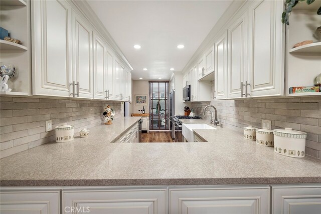 kitchen featuring white cabinetry, appliances with stainless steel finishes, dark wood-type flooring, and backsplash