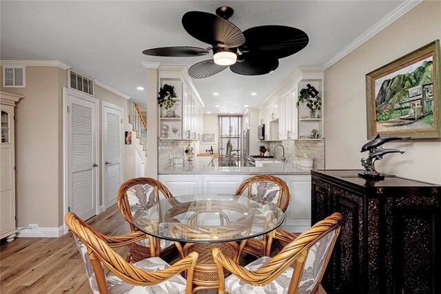 dining area with ornamental molding, light hardwood / wood-style floors, and ceiling fan