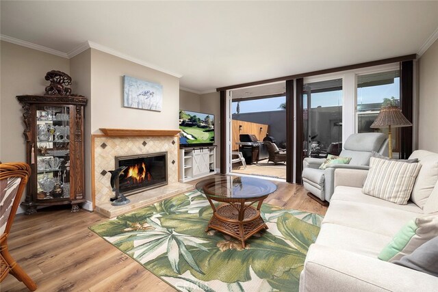 living room with a fireplace, ornamental molding, and hardwood / wood-style floors