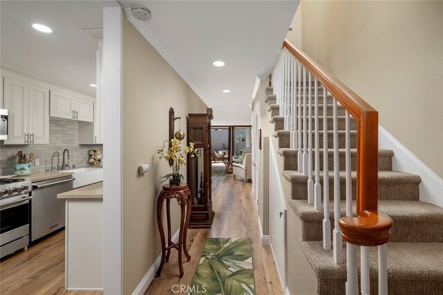 interior space with ornamental molding, hardwood / wood-style floors, and sink