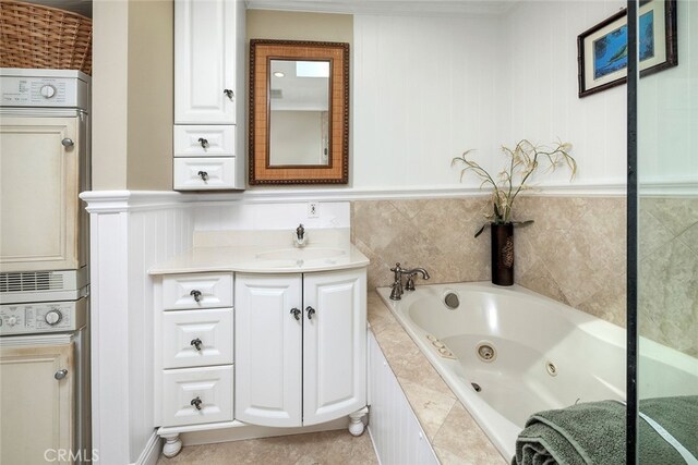 bathroom featuring tiled tub, vanity, and tile patterned floors