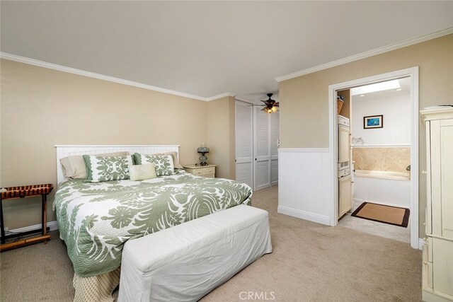 bedroom with light colored carpet, ensuite bath, and crown molding