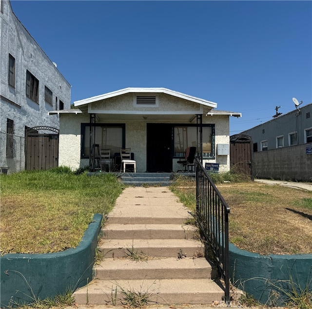 bungalow-style home with a front lawn