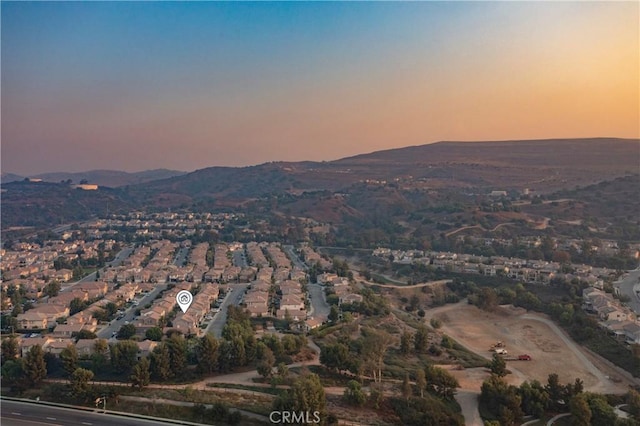 aerial view at dusk featuring a mountain view