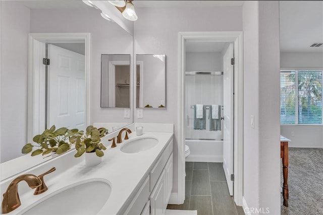 full bathroom featuring vanity, toilet, and bath / shower combo with glass door