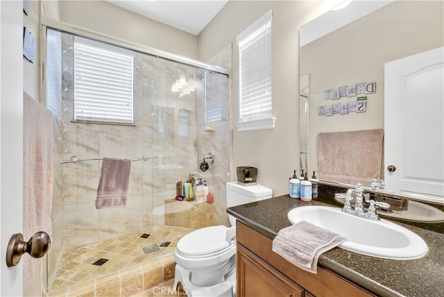 bathroom featuring vanity, walk in shower, and toilet