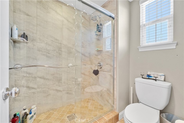 bathroom featuring toilet and a shower with shower door