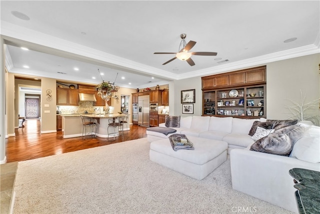 living room with ceiling fan, light wood-type flooring, and crown molding