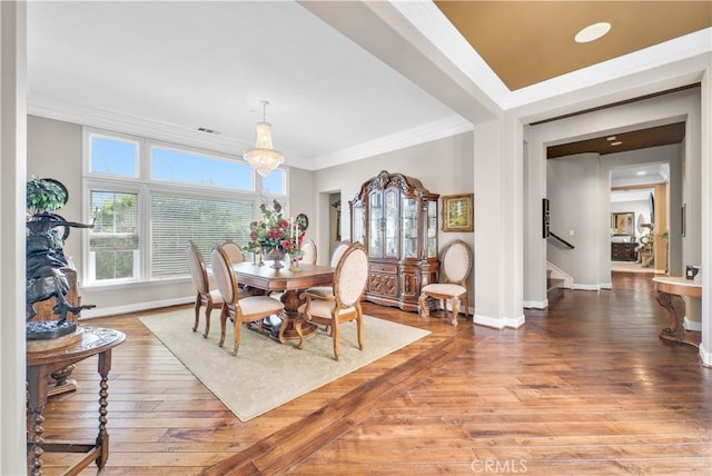 dining space featuring ornamental molding, a notable chandelier, and hardwood / wood-style floors