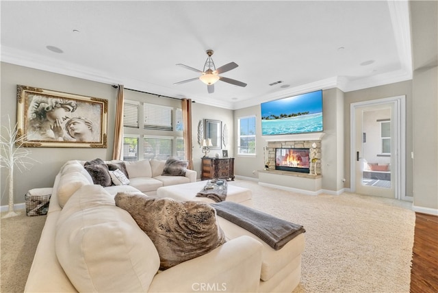 living room featuring ornamental molding, a fireplace, ceiling fan, and wood-type flooring