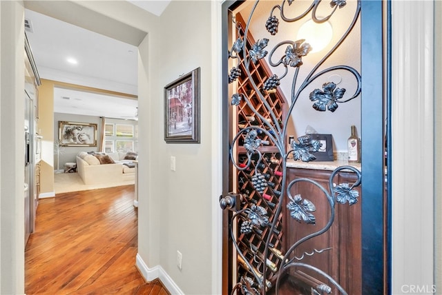 wine area with crown molding and hardwood / wood-style floors