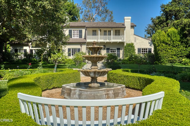 view of front of house with a front yard and a balcony