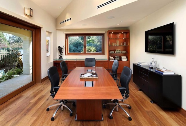 office area with light hardwood / wood-style flooring and vaulted ceiling