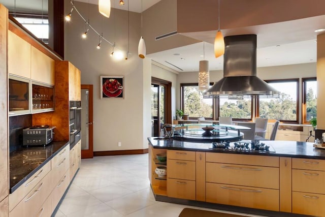 kitchen featuring light brown cabinets, black gas stovetop, plenty of natural light, and island exhaust hood