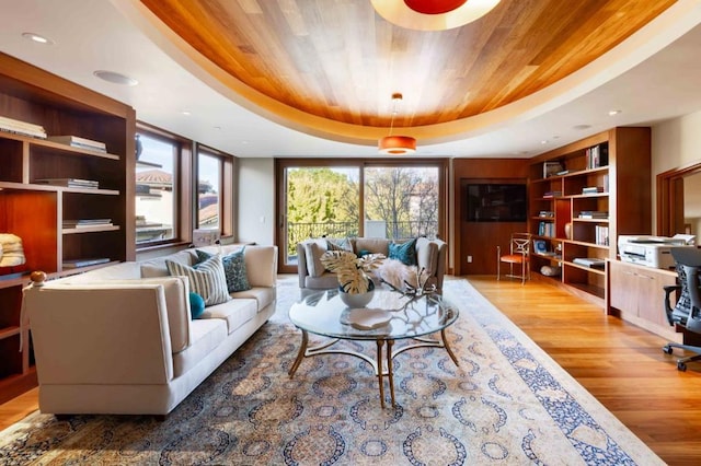 living room featuring hardwood / wood-style flooring, a tray ceiling, and wood ceiling