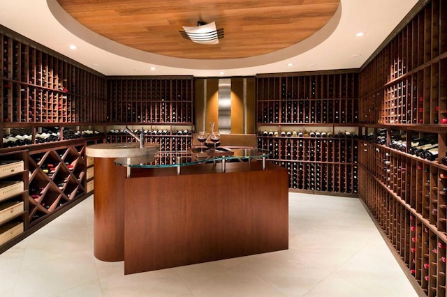 wine room featuring a raised ceiling, light tile patterned flooring, and wooden ceiling