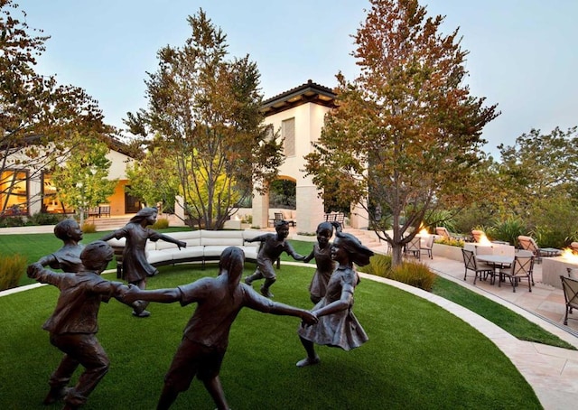 view of home's community featuring a patio area and a lawn