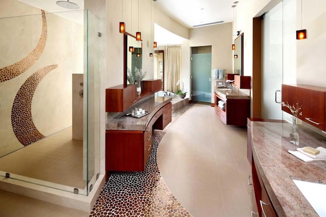 bathroom with tile patterned floors, walk in shower, and vanity