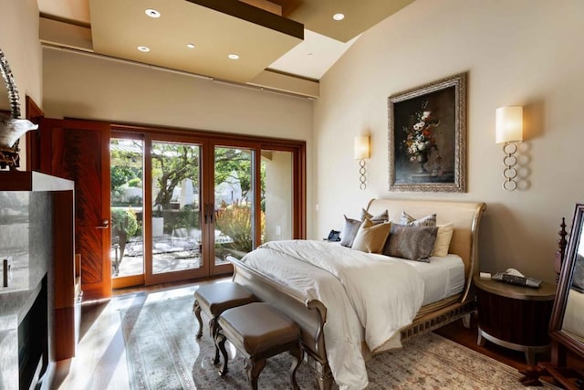 bedroom with vaulted ceiling, light hardwood / wood-style flooring, and access to exterior