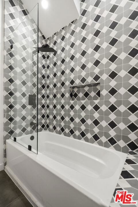 bathroom featuring bathing tub / shower combination and tile patterned flooring