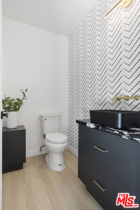 bathroom featuring vanity, toilet, and hardwood / wood-style floors