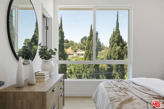 bedroom featuring light hardwood / wood-style flooring and multiple windows