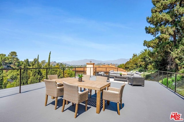 view of patio / terrace featuring an outdoor living space, a mountain view, and a balcony