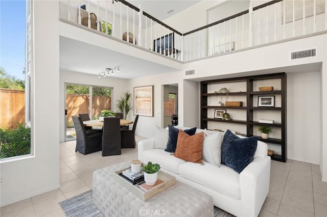 living room with light tile patterned floors and a high ceiling