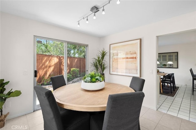 dining area with light tile patterned floors and rail lighting