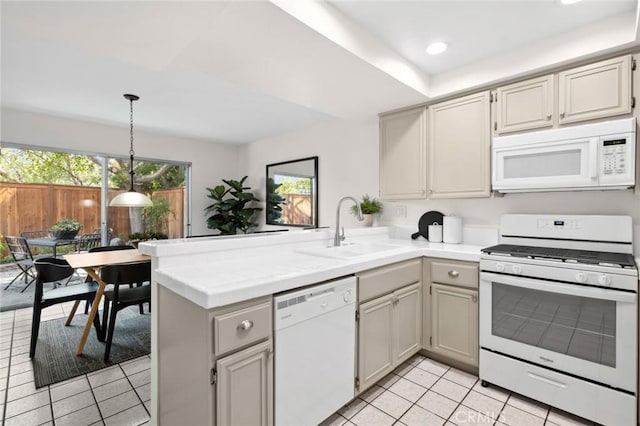 kitchen with kitchen peninsula, white appliances, sink, decorative light fixtures, and light tile patterned flooring