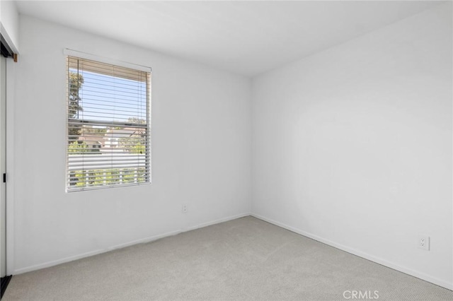 unfurnished room featuring light carpet