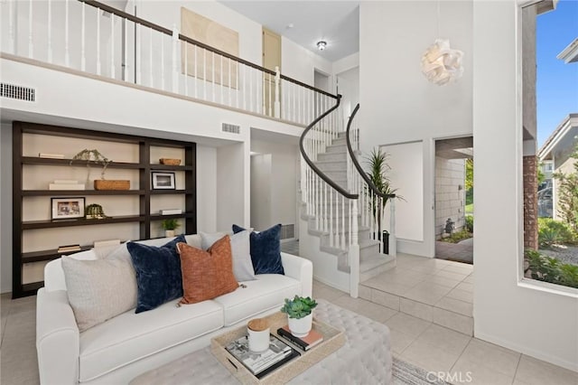 living room with light tile patterned floors and a high ceiling