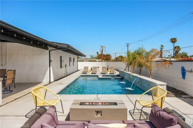 view of swimming pool with an outdoor fire pit, a jacuzzi, a patio area, and pool water feature