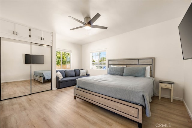 bedroom with ceiling fan, light wood-type flooring, and a closet